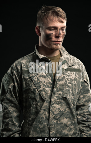 Militärische junger Mann mit Tarnung auf Gesicht. Studio gedreht. Stockfoto