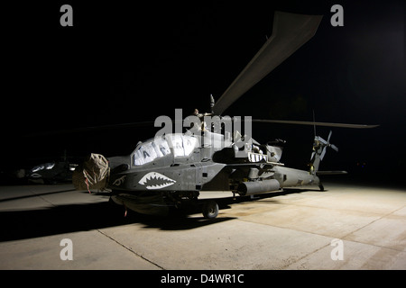 Handwerker arbeiten an einem AH - 64D Apache Longbow nachts auf einer Militärbasis im Irak. Stockfoto