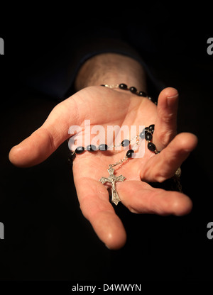 Helfende Hand festhalten Rosenkranz und Kreuz. Stockfoto