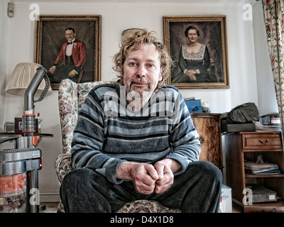 Porträt von einem schmuddeligen Mann mittleren Alters in einem Mittelklasse-Salon Stockfoto