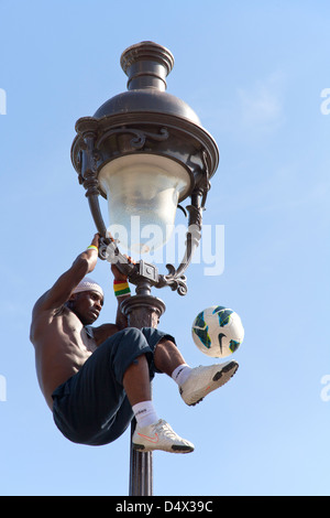 akrobatische Performance-Künstlerin in einem alten Gaslampe auf die Hügel von Sacre Coeur in Montmartre Paris Stockfoto