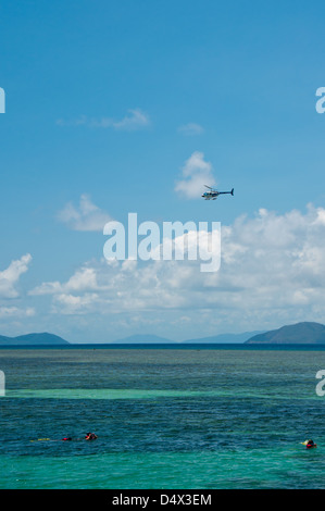 Great Barrier Reef. Ein Hubschrauber bringt Touristen zu Green Island während Schnorchler einen sonnigen Sommertag unten genießen. Stockfoto