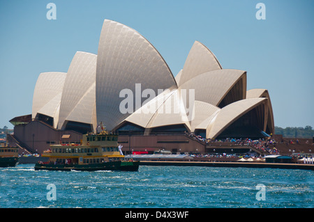 Sydney Opera House. Eine Fähre bringt Besucher vorbei an das legendäre Gebäude an einem sonnigen Sommertag. Stockfoto