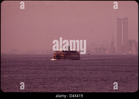 Staten Island Ferry mit Smog-Obscured Skyline von Lower Manhattan im Hintergrund. Auf der rechten Seite sind die Twin Towers des World Trade Center mit Blick auf den Hudson River 05/1973 Stockfoto