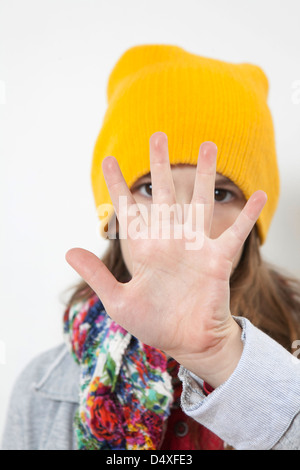 Mädchen in gelben Hut verbirgt ihr Gesicht mit der hand Stockfoto