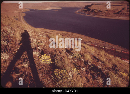 Ein Foto vom Mai 1973, das die Columbia River Gorge in Wishram, Washington, mit einer Eisenbahn im Vordergrund zeigt. Das Bild hebt die malerische Landschaft und die Transportroute hervor. Stockfoto