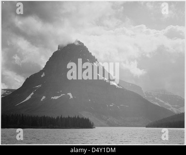 Ansel Adams hat dieses beeindruckende Schwarzweiß-Bild des Two Medicine Lake im Glacier National Park, Montana, aufgenommen. Das Foto zeigt die bergige Landschaft und das ruhige Wasser des Parks. Stockfoto