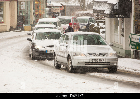 Autos fahren über Ambleside im Schnee, Lake District, Großbritannien. Stockfoto