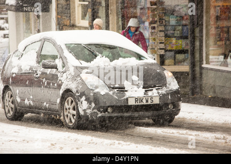 Autos fahren über Ambleside im Schnee, Lake District, Großbritannien. Stockfoto