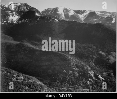 Ansel Adams hat dieses Schwarzweiß-Foto des Rocky Mountain National Park in Colorado aufgenommen und die bewaldeten Hügel des Parks mit den majestätischen Bergen im Hintergrund gezeigt, was die natürliche Schönheit der Region unterstreicht. Stockfoto