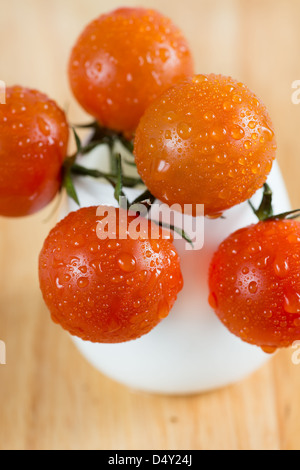 Frische Tomaten in einer weißen Vase auf einem hellen Holz Hintergrund, Closeup, selektiven Fokus Stockfoto