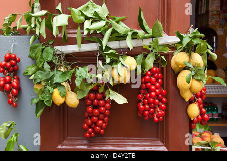 Zitronen und Tomaten vor einem Lebensmittelladen in Massa Lubrense, Italien hängen Stockfoto