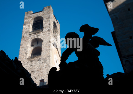 Bergamo - Statue des Engels vom Tor des Baptisterium am Piazza del Duomo und Torre del Comune im Hintergrund Stockfoto