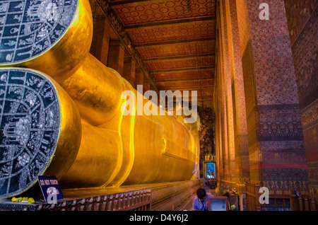 Details zu den goldenen liegenden Buddha im Wat Po Bangkok Stockfoto