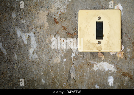 alte Energie Licht Umschalter an Betonwand Stockfoto