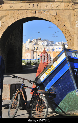 Marokkanischer Mann, der einen Djellaba trägt - die traditionellen Winter-Poncho-Mäntel mit Kapuzen, in der Nähe des Bab El Marsa Tores, Essaouira, Marokko Stockfoto