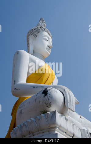 Thailand, Ayutthaya. Wat Phra Chao Phaya Thai (aka Wat Yi Chai-Mongkol). Sitzende Buddha-Statue in gelben Gewand. UNESCO Stockfoto