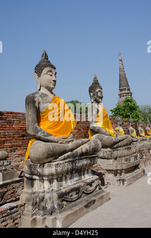 Thailand, Ayutthaya. Wat Phra Chao Phaya Thai. Linie der sitzende Buddha-Statuen in gelben Gewändern gekleidet. UNESCO Stockfoto