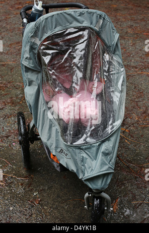 Ein Baby im Kinderwagen an einem regnerischen Tag wasserdicht. Stockfoto