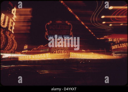 Ein Foto von 1972, das die Nachtlichter der Fremont Street in Las Vegas zeigt, mit dem Four Queens Casino und Golden Nugget im Hintergrund. Das Bild fängt das pulsierende Nachtleben und die berühmten Kasinos von Las Vegas ein. Stockfoto