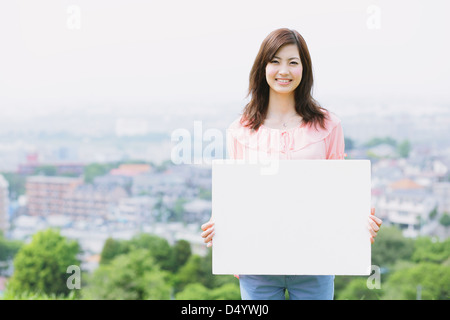 Japanerin mit einem Whiteboard lächelnd in die Kamera Stockfoto