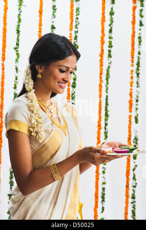 Südindische Frau hält eine Puja-Thali in Onam Stockfoto