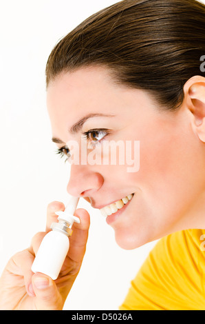 Eine glückliche Frau, die mit Nasenspray Stockfoto