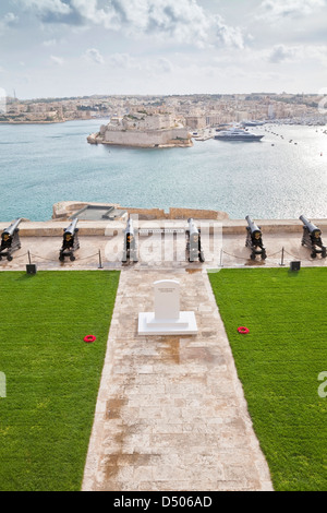 Kanonen mit Blick auf Valletta Grand Harbour, Malta am Gedenktag mit dem Denkmal im Vordergrund. Stockfoto