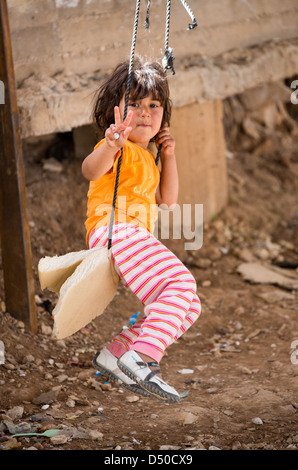 Eine junge syrische Mädchen auf einem provisorischen Wsing machen ein Victory-Zeichen im König Abdullah Flüchtlingslager in Jordanien nahe der syrischen Grenze Stockfoto