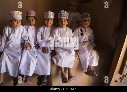 Omanische Schuljungen tragen Traditionsgericht Dash und Kopfschmuck auf Schulbesuch zum Fort in Nizwa, Oman Stockfoto