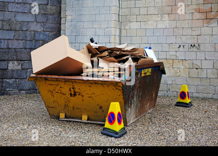 Ein Müll überspringen voller Pappe für das recycling. Stockfoto