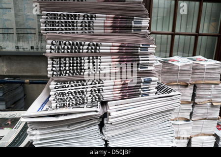 Stapel von Zeitungen auf einem Zeitungsstand vor einer U-Bahnstation In Central City of London, England, Großbritannien, KATHY DEWITT Stockfoto