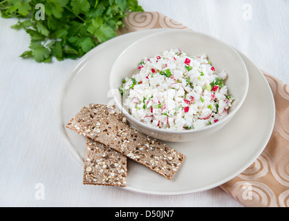 Frischer Salat mit Radieschen und Kräutern, Knäckebrot auf Seite Stockfoto
