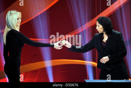 OK Präsidentin Steffi Jones erhält die Partie für Deutschland von Model Adriana Karembeu (l) während des Zeichnens für die FIFA Frauen Weltmeisterschaft 2011 in Frankfurt am Main, 29. November 2010. Die FIFA Frauen WM findet vom 26. Juni bis 17. Juli 2011 in Deutschland. Foto: Boris Roessler Stockfoto