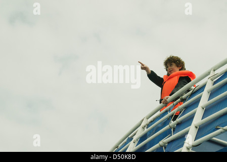 Junge beobachtete den Horizont auf dem oberen Deck eines Bootes Stockfoto