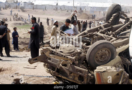 Sicherheitsbeamte und Menschen versammeln sich auf dem Gelände nach Bombenexplosion im Jalozai Camp in Nowshera auf Donnerstag, 21. März 2013. Mindestens 15 Menschen, darunter Frauen und Kinder wurden getötet, während mehrere andere in einer Explosion verletzt worden sind, die im Jalozai Camp aufgetreten sind. Bombe Abgang im Kader (BDS) offizielle Abdul Haq, dass rund 35 Kilogramm das explosive Material gesagt diente in der Explosion. Stockfoto