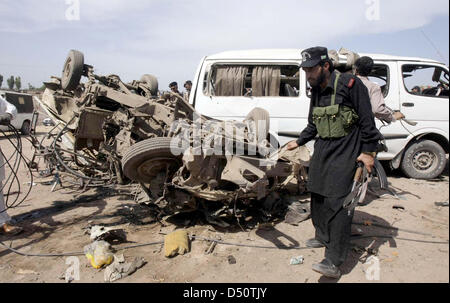 Sicherheitsbeamte und Menschen versammeln sich auf dem Gelände nach Bombenexplosion im Jalozai Camp in Nowshera auf Donnerstag, 21. März 2013. Mindestens 15 Menschen, darunter Frauen und Kinder wurden getötet, während mehrere andere in einer Explosion verletzt worden sind, die im Jalozai Camp aufgetreten sind. Bombe Abgang im Kader (BDS) offizielle Abdul Haq, dass rund 35 Kilogramm das explosive Material gesagt diente in der Explosion. Stockfoto