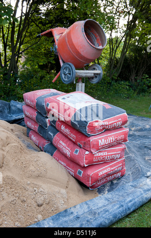 Close-up Tools & Garten- und Landschaftsbau Ausrüstung (Cement Mixer, Säcke Zement & Sandhaufen auf Plane) - Yorkshire, England, UK. Stockfoto