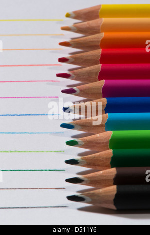 Close-up Detail von scharfen bunte Bleistiftzeichenstifte gelegt Seite an Seite auf weißem Papier Hintergrund von Zeilen in jeder Farbe - Yorkshire, England, UK. Stockfoto