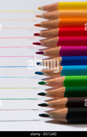 Close-up Detail von scharfen bunte Bleistiftzeichenstifte gelegt Seite an Seite auf weißem Papier Hintergrund von Zeilen in jeder Farbe - Yorkshire, England, UK. Stockfoto