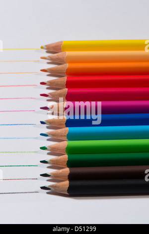 Close-up Detail von scharfen bunte Bleistiftzeichenstifte gelegt Seite an Seite auf weißem Papier Hintergrund von Zeilen in jeder Farbe - Yorkshire, England, UK. Stockfoto