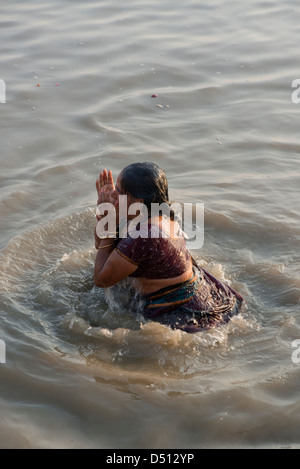 Ein Hindu Anhänger engagiert sich im Ritual Baden im Heiligen Yamuna Fluß bei Sonnenaufgang am Vishram Ghat, Mathura, Uttar Pradesh, Indien Stockfoto