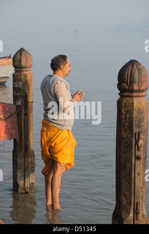 Ein Hindu Anhänger betet im heiligen Fluss Yamuna bei Sonnenaufgang am Vishram Ghat, Mathura, Uttar Pradesh, Indien Stockfoto