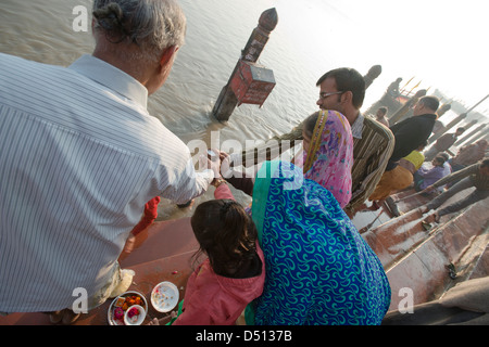 Eine Hindufamilie teilen eine rituelle Angebot von Milch, der Heilige Fluss Yamuna am Vishram Ghat, Mathura, Uttar Pradesh, Indien Stockfoto