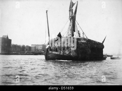 Der Heuhahn „Unity“ wird an der Wapping Dock Treppe vorbei gesehen, wobei Lower Gun Wharf und New Crane Wharf auf der Steuerbordseite sichtbar sind. Diese Szene aus dem National Maritime Museum zeigt die geschäftige maritime Aktivität entlang der Themse. Stockfoto