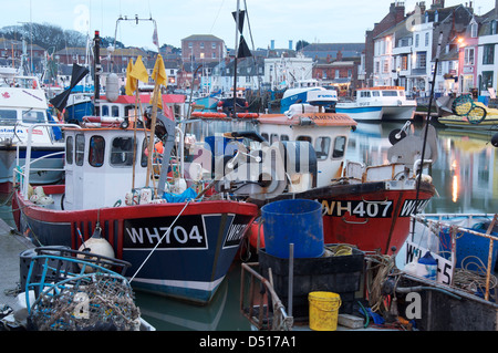 Englische Südküste Stadt am Meer. Bunte Fischerboote vertäut neben Custom House Quay im Hafen von Weymouth, Dorset, England, Vereinigtes Königreich. Stockfoto