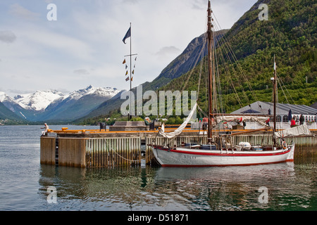 1908 gebaute Yacht ankern Solli in Andalsnes, Romsdalfjord, Norwegen, als ein Angler Fische vom Ende des Piers Stockfoto