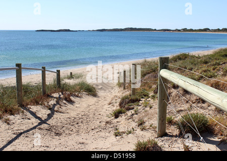 An einem ruhigen, sonnigen Nachmittag im Spätherbst führt ein sandiger Weg hinunter zum Badestrand von Rockingham Western Australia. Stockfoto