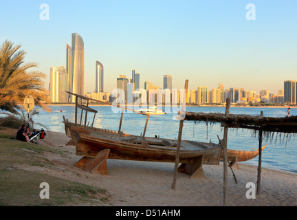 Traditionellen Dhau am Strand, moderne Hochhäuser im Hintergrund, Abu Dhabi Heritage Village, Vereinigte Arabische Emirate Stockfoto