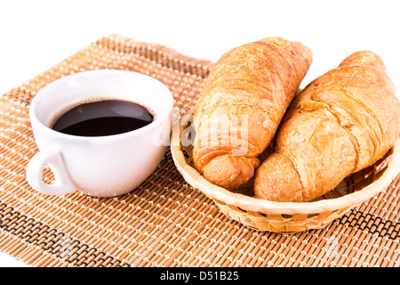 Frische und leckere französische Croissants in ein Korb und eine Tasse Kaffee serviert isolierten auf weißen Hintergrund Stockfoto